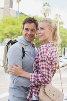 Young tourist couple hugging each other on a sunny day in the city