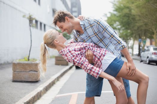 Hip romantic couple dancing in the street on a sunny day in the city