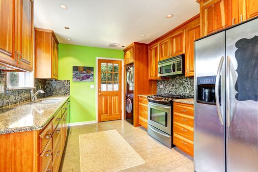 Maple kitchen cabinets with mosaic back splash trim and granite tops. Bright kitchen room with green wall