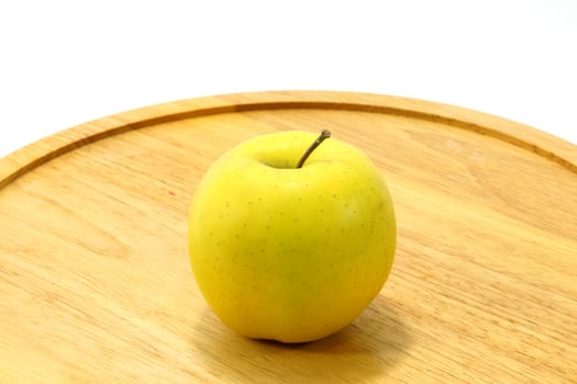 Yellow apple on wood