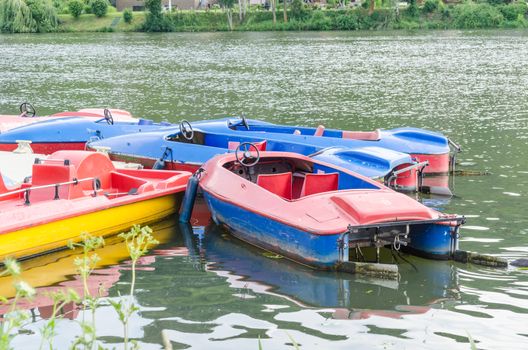 Red blue pedal boats at the dock for hire on the Ruhr reservoir in Essen Kettwig