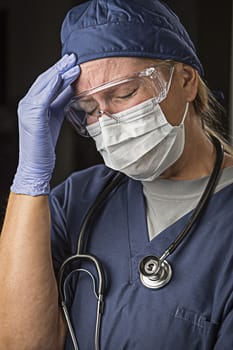 Grimacing Female Doctor or Nurse Wearing Protective Facial Wear and Surgical Gloves.