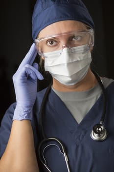 Concerned Female Doctor or Nurse Wearing Protective Facial Wear and Surgical Gloves.