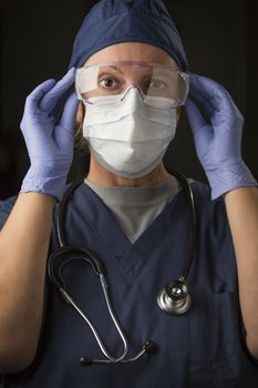 Concerned Female Doctor or Nurse Putting on Protective Facial Wear.