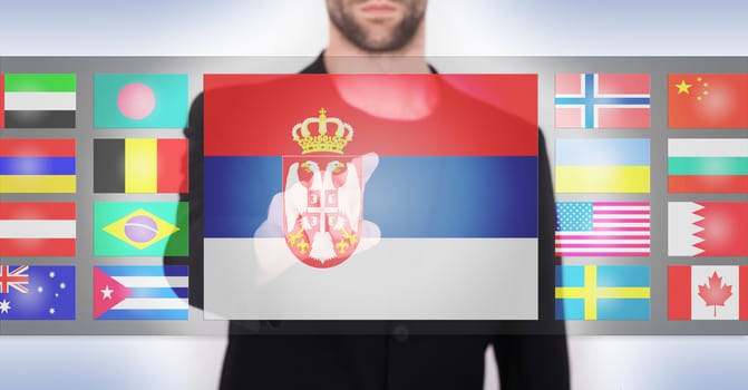 Hand pushing on a touch screen interface, choosing language or country, Serbia