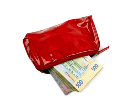 Stack of paper money in the women's bright red purse on white background