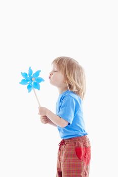 studio shot of a boy playing with pinwheel - isolated on white