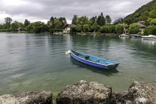 An empty rowing boat floating on the green colored water of a beautiful lake in The Alps, Europe