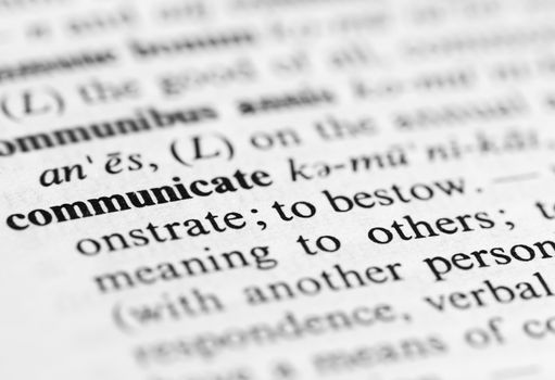 Close up of the word 'communicate' and its definition in the dictionary