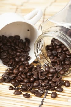 Coffee beans in a jar.coffee beans in white cup on table wooden.