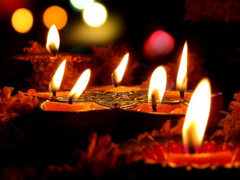 Beautiful lamps surrounded with flowers for a traditional ritual during Diwali festival