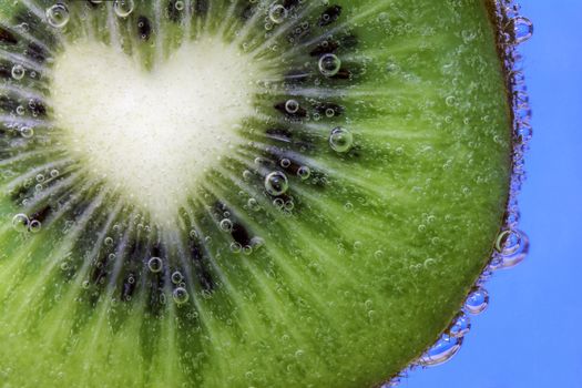 Closeup of a heart shaped kiwi slice covered in water bubbles