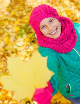 Portrait of Adorable cute girl with autumn leaves in the beauty park