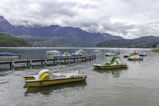 Colorful empty pedalos scattered out on a beautiful lake at the end of the summer season