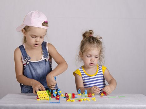 Two girls playing in the constructor, are collected from a parts car. Very passionate about the matter