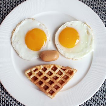 Breakfast meal with egg ausage and waffle