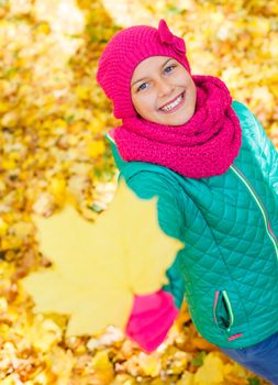 Portrait of Adorable cute girl with autumn leaves in the beauty park