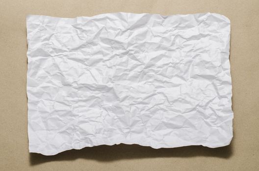 a4 size white crumpled paper on brown color background