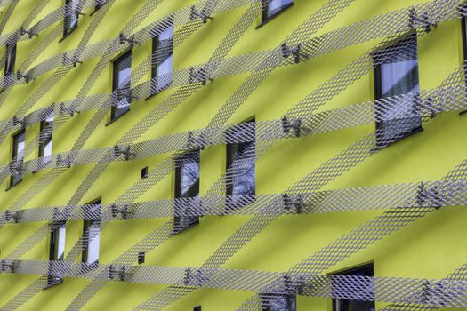 Striking and unusual looking modern yellow office building with metal mesh lattice pattern