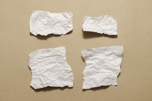 piece of white crumpled paper on brown background