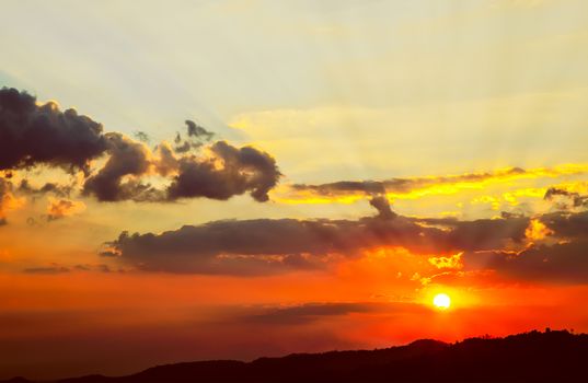 Beautiful red sky with sunbeams and clouds, sunset on high mountain