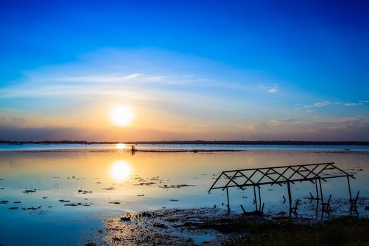 sunset sky over lake or river and home with flood