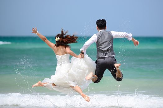 happy just married young couple celebrating and have fun at beautiful beach