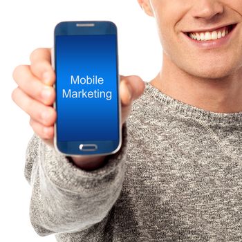 Hand holds phone with mobile marketing words on its screen
