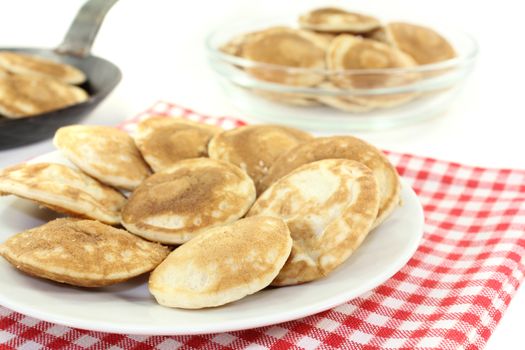 Dutch Poffertjes on a plate before light background