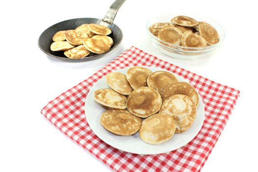 delicious Dutch Poffertjes on a plate before light background