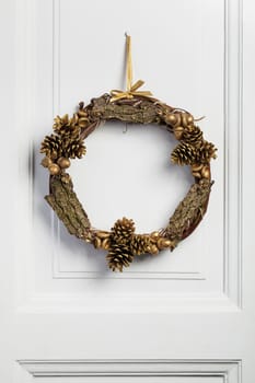 Twig wreath of dried vine, decorated with pine cones, acorn and bark.