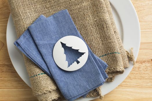 Plastic tree shaped biscuit cutter on blue napkin.