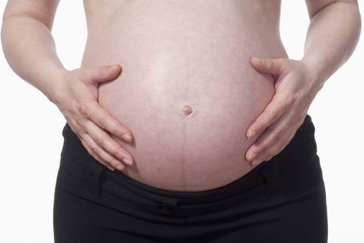 closeup of a pregnant woman touching her belly - isolated on white