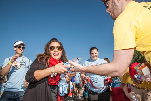 TUCSON, AZ/USA - OCTOBER 12:  Young man distributing water to AIDSwalk participants on October 12, 2014 in Tucson, Arizona, USA.
