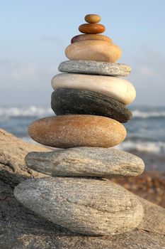 Pile of beach stones delicately stacked with the sea in the background