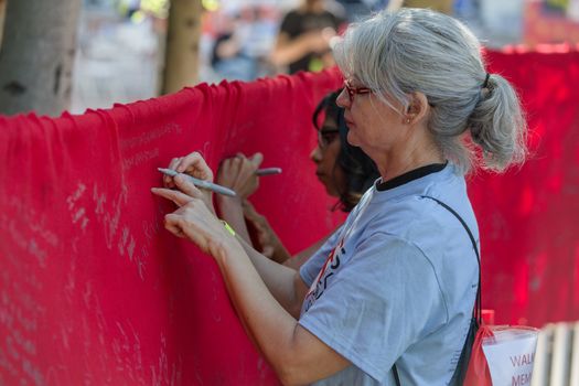 TUCSON, AZ/USA - OCTOBER 12:  Unidentified people writing on memorial AIDS ribbon on October 12, 2014 in Tucson, Arizona, USA.