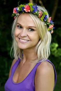 Pretty blond woman with a wreath of pretty spring flowers on her head
