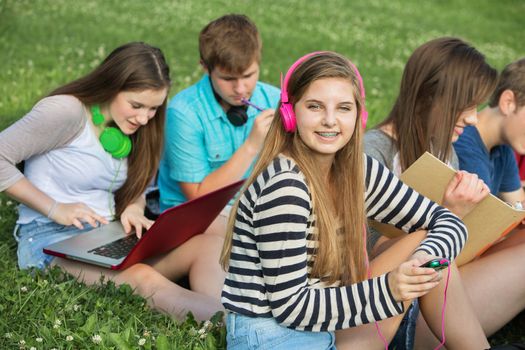 Happy teen with male and female friends outdoors