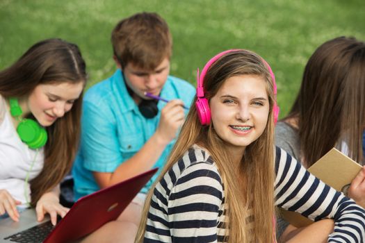 Smiling cute teen girl with braces and pink headphones