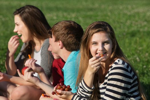 Cute teen girl with friends eating healthy food