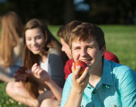 Happy young person with friends holding fruit