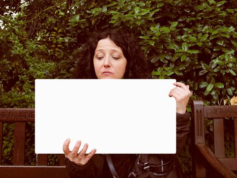 A young sexy goth brunette girl holding a blank banner board