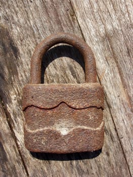 Old rusty padlock on wooden background