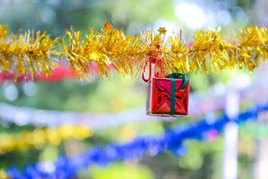 Closeup red gift box, christmas ornament hanging on tree