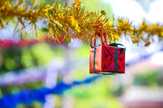 Closeup red gift box, christmas ornament hanging on tree