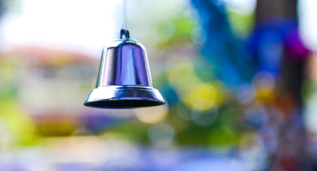 Closeup of silver bell, christmas ornament hanging on tree