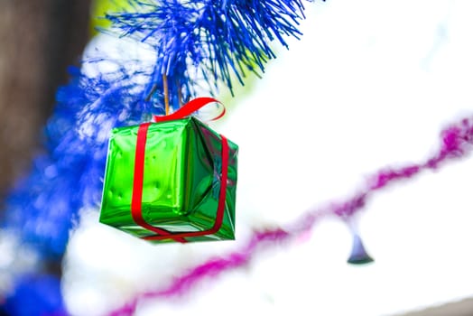 Closeup geen gift box, christmas ornament hanging on tree