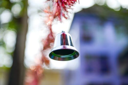 Closeup of silver bell, christmas ornament hanging on tree