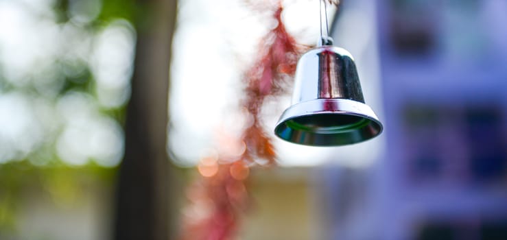 Closeup of silver bell, christmas ornament hanging on tree