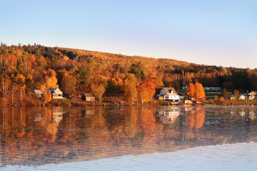 Autumn countryside of New Brunswick Canada along the Saint John River with reflections on the water during sunset